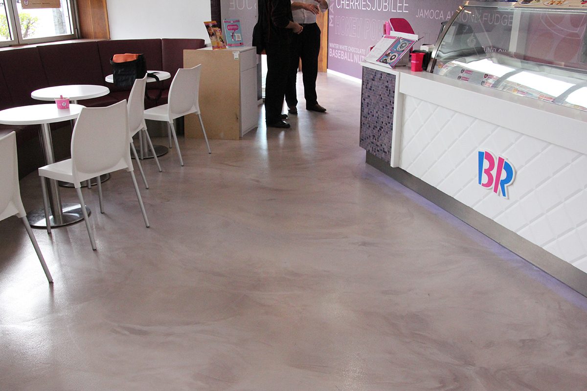 A photo showing the front entrance, seating area and edge of the long service counter, as well as the semi-gloss finish of the new metallic epoxy.