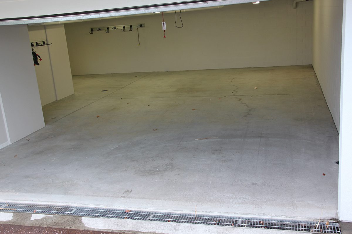 The garage with door open showing the bare concrete that was in place before the metallic epoxy floor was installed.
