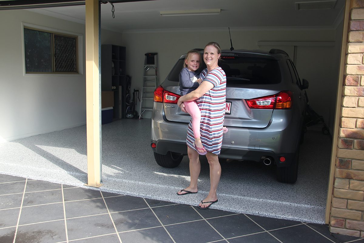 Another angle of the front of the residential garage with the smiling homeowner and her daughter standing at the opening.