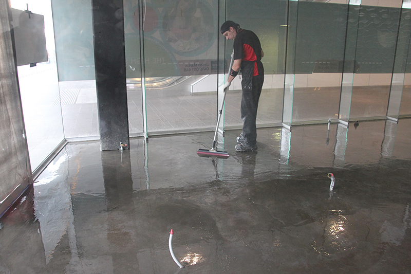 An installer using specialist equipment to apply a metallic epoxy floor.