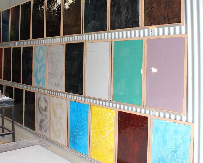Sampleboards of metallic epoxy flooring on a wall.