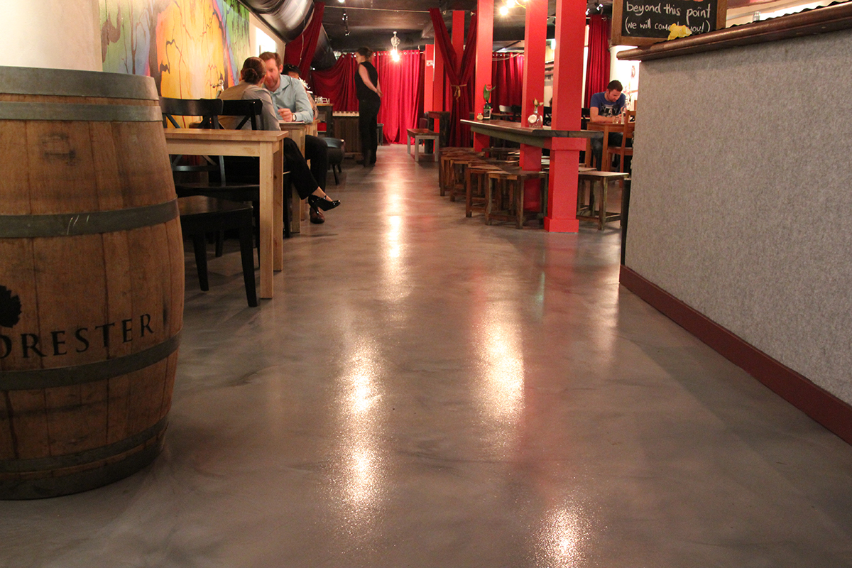 A metallic epoxy flooring system from Real World Epoxies in the seating area of a trendy city cafe.